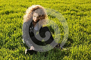 Beautiful lady with her laptop on grass