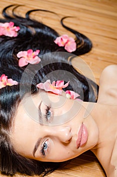 Beautiful lady with orchid flowers in hair. Perfect skin. NoPhotoshop