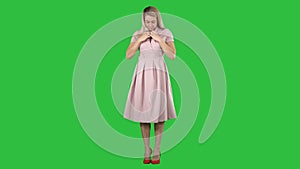 Beautiful lady in pink dress preen on a green screen, chroma key.