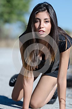 Beautiful lady posing on the rural road in a black dress