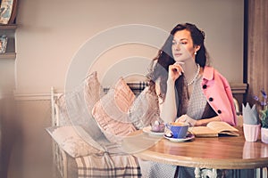 Beautiful lady reading novel in a cafe