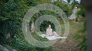 Beautiful lady relaxing picnic blanket in garden. Woman sitting green grass park