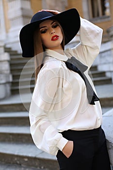 Beautiful ladylike woman in elegant blouse and felt hat