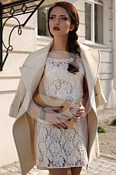 Beautiful ladylike woman in elegant wool coat and lace dress