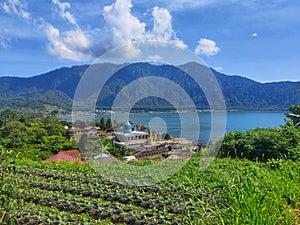 a beautiful lake in Bali with a mountain range behind it