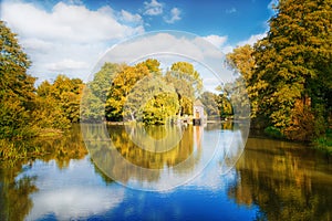 Beautiful Lake With Blue Cloudy Sky And Water Reflection - Dam And Lodge In Background