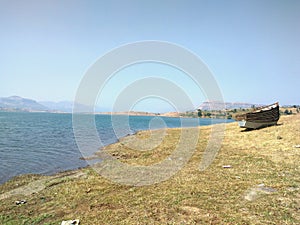 Beautiful lake boat standing blue sky hill background photo