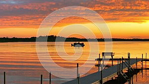 Beautiful Lake Irving at sunset as a pontoon floats past a boat dock.