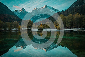 Beautiful lake jasna in kranjska gora with visible reflections of Razor and Skrlatica in the water in early autumn