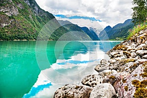 Beautiful lake in the mountains and view of Briksdal glacier in Norway.