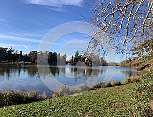 Beautiful lake natural landscape with transparent water with reflection, sunny autumn day blue sky with some clouds and gazebo