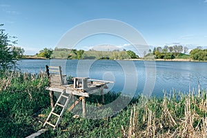 Beautiful lake with placing for fishing under blue sky on a sunny day. Scenic summer landscape, selective focus