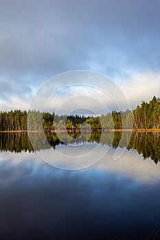 Beautiful lake scenery in Finland. Water mirroring  the sky and the woods