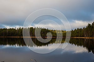 Beautiful lake scenery in Finland. Water mirroring  the sky and the woods