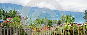Beautiful lake shore Brienzersee, wooden fence and flower garden, tourist destination Iseltwald switzerland