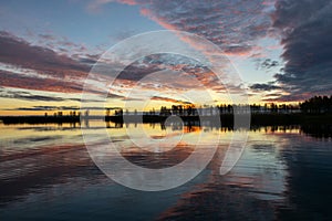 Beautiful lake at sunrise, golden hour sunrise, sunlight and grand cloud reflections on water, colorful dramatic sky at sunrise