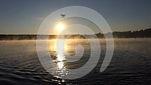 A beautiful lake at sunset and a drone flying over it in slo-mo