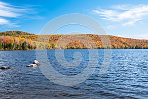 Beautiful lake surrounded by forested hills on a clear autumn day