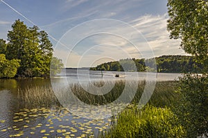 Beautiful lake view with motor boat on blue sky with white clouds background. Beautiful summer nature backgrounds.