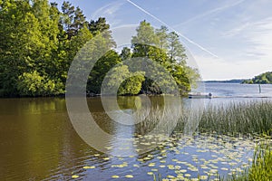 Beautiful lake view with motor boat on blue sky with white clouds background. Beautiful summer nature backgrounds. Sweden,