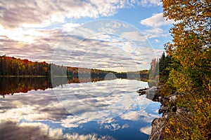 Beautiful lake with wooded shores at sunset in autumn