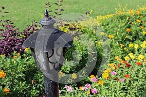 Beautiful lamp post in a garden with colorful flowers