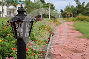 Beautiful lamp post to light up walkway in a garden with colorful flowers