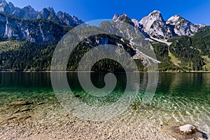 Beautiful landscape of alpine lake with crystal clear green water and mountains in background, Gosausee, Austria