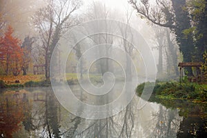 Beautiful landscape of an autumn lake with forest and fog