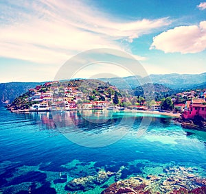 Beautiful landscape with bay and colorful buildings on the background of picturesque clouds in the town of Asos, Greece, Kefalonia