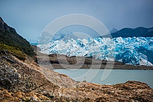 Beautiful landscape of a blue glacier and mountains with a bay. Shevelev.