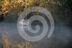 Beautiful landscape of a boat in a lake surrounded by trees in autumn.