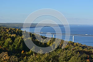 Beautiful landscape with bridge over the Volga river and forest on the bank. Blue water and sky. The beginning of autumn.