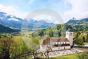 Beautiful landscape with church in Gruyeres,Switzerland. Alps mountains and fields, pretty summer day.