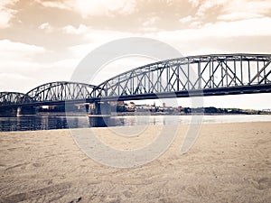 Beautiful landscape of a European city metal bridge across the river near the beach
