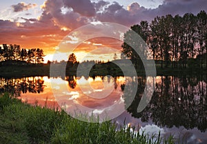 Beautiful landscape with fiery sunset over the lake