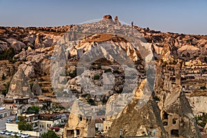 Beautiful landscape of Goreme on sunrise.Cappadocia.Turkey. View of rock formations fairy chimneys, hotels and houses at the cave.