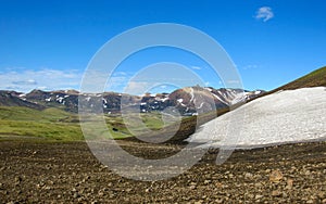 Beautiful landscape of green Hvanngil valley and rhyolite mountains covered with snow, Laugavegur Trail, Highlands of Iceland