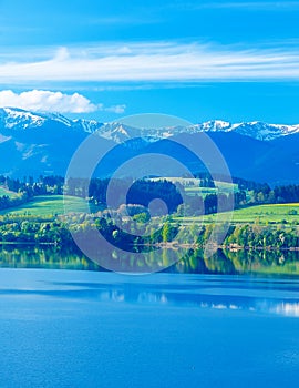 Beautiful landscape, green meadow and lake with mountain in background. Slovakia, Central Europe.