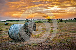 Beautiful landscape with hay bales at sunset