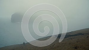 Beautiful landscape in Iceland. Young woman walking on the shore of the sea and exploring the new places.