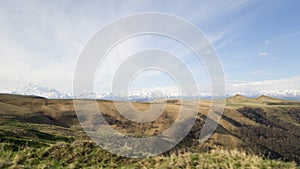 Beautiful landscape of Karachay-Cherkessia in Russia. Beautiful fields and a mountain range in the background. Elbrus. Spring