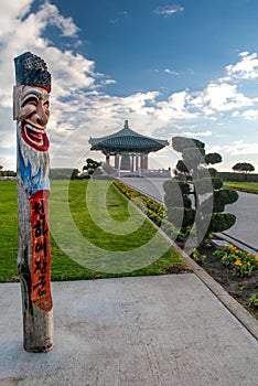 Beautiful landscape of the Korean Friendship Bell in a lush green park with a colorful pole statue