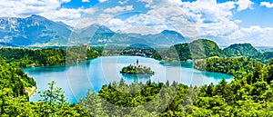 Beautiful landscape of Lake Bled the church island in the middle and the castle in the background of white clouded sky from