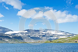 Beautiful landscape with Lake Finsevatnet, snowy mountains and glacier Hardangerjokulen in Finse, Norway