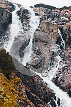 A beautiful landscape with a large mountain waterfall and water