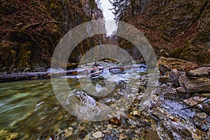 Landscape with a mountain river with small waterfalls in winter day in the canyon