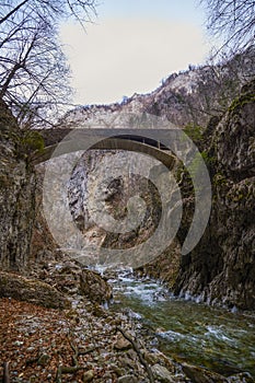 landscape with a mountain river with small waterfalls in winter day in the canyon