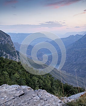 A beautiful landscape of mountains with bushes, rocks and a river on a summer day at sunset. Sulak Canyon