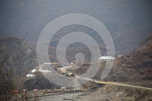 Beautiful landscape of mountains and forest with village building or old abandoned ruined brick house. Foggy forest and old buildi